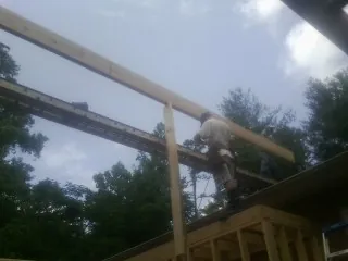 Carpenter setting a ridge beam over a new addition frame — Ice Dam Removal by Roofing Brothers in Reevesville